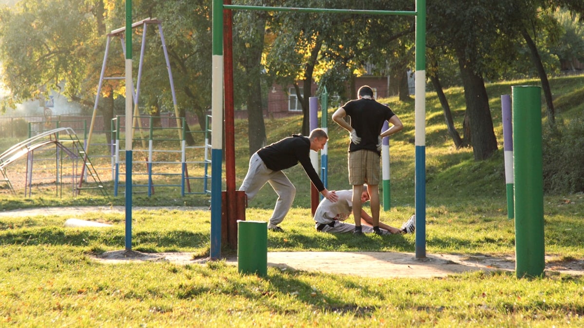 Two men and a dog at an outdoor gym